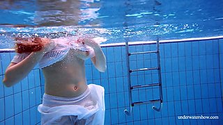 Stunning red haired porn model Marketa shows striptease under the water